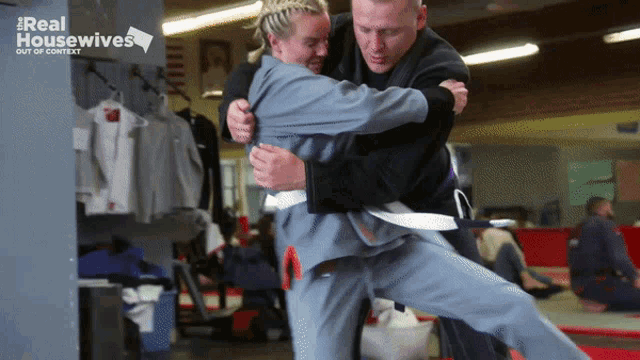 a man is wrestling a woman with a real housewives logo in the background
