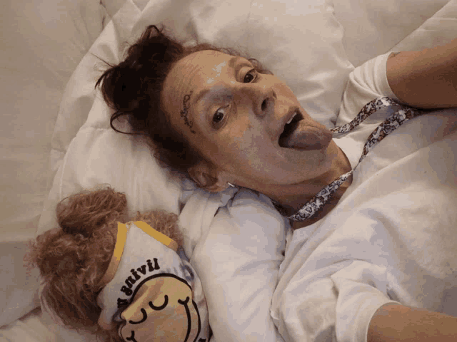 a woman laying on a bed with a shirt that says vivi