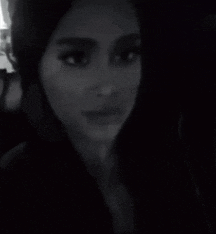 it is a black and white photo of a woman taking a selfie .
