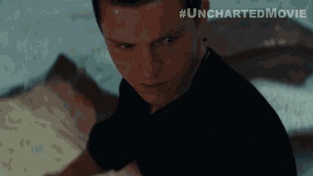 a close up of a man 's face with #unchartedmovie written on the bottom right