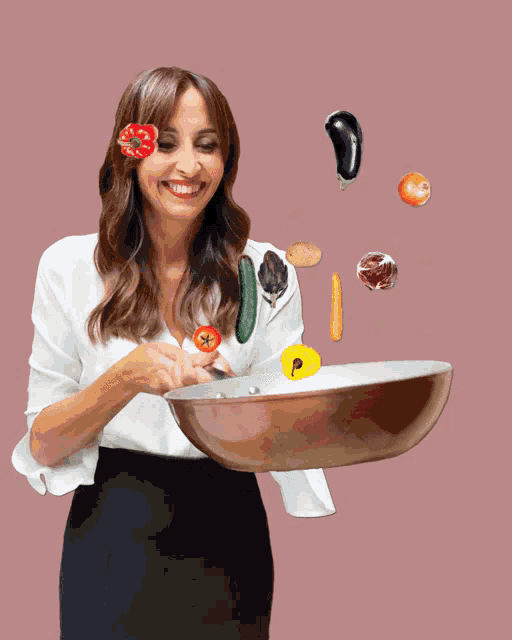 a woman is holding a frying pan with vegetables flying around her