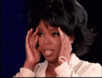 a woman is holding her head with her hands while looking at the camera .