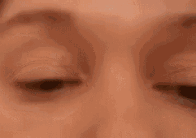 a close up of a woman 's eyes with a surprised look on their face .