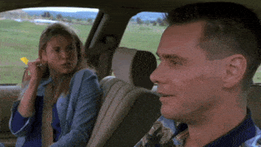 a man and a woman are sitting in a car talking