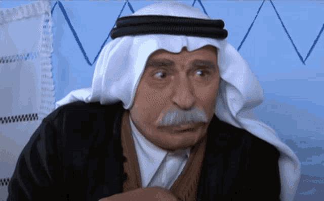 a man with a mustache wearing a head scarf