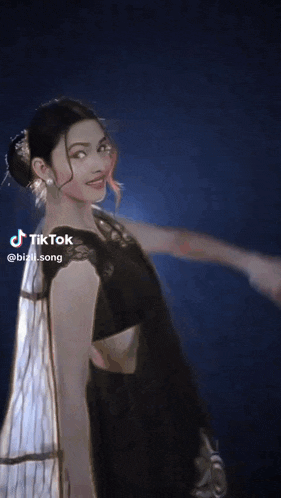 a woman is holding a flower in front of her face with a tiktok watermark
