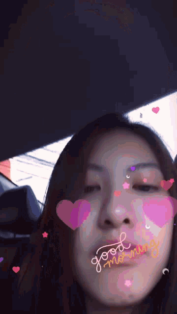 a woman in a car with hearts on her face and the word morning written on the bottom