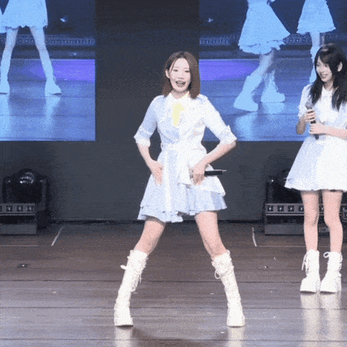 a woman in a blue and white dress stands on one leg on a stage