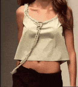 a woman wearing a crop top with a braided neckline