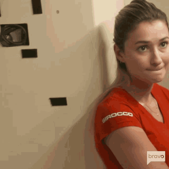 a woman wearing a red shirt with sirocco on the sleeve