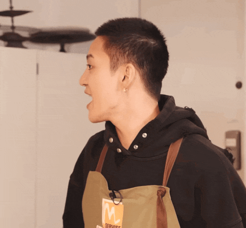 a man wearing an apron that says servise