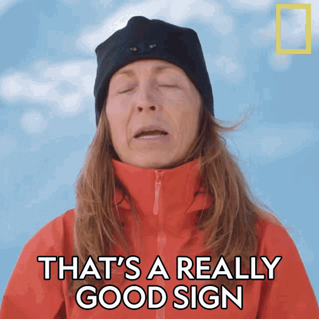 a woman wearing a red jacket and black hat says that 's a really good sign