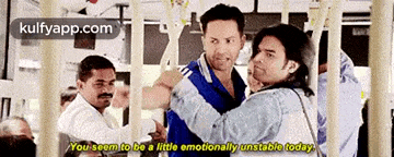 a group of men are standing next to each other on a bus and one of them is talking about being emotionally unstable .