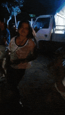 a woman is dancing in front of a truck that says ' toyota ' on it