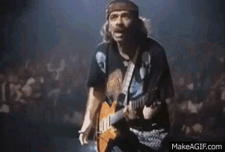 a man in a skull shirt is playing a guitar on a stage .