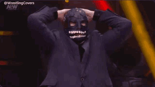 a man wearing a mask and a suit is on a wrestling show
