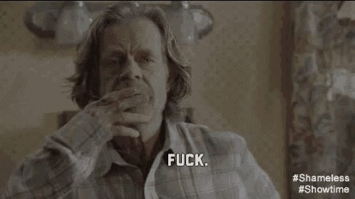 a man in a plaid shirt is sitting in a room and says fuck .