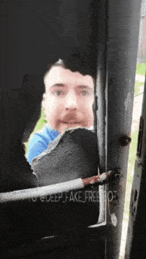 a man 's face is visible through a hole in a door that says deep fake freebot