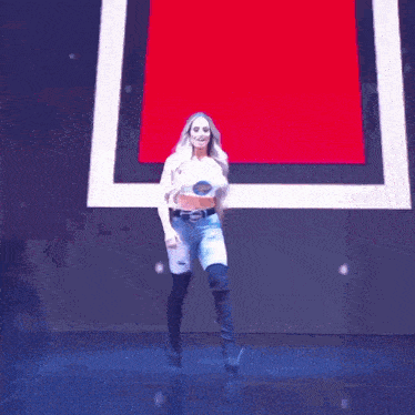 a woman in a crop top and shorts is dancing on stage