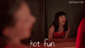 a woman in a red dress is looking at herself in a mirror with the words hot fun written on the bottom