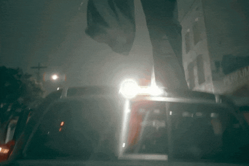 a person standing on top of a car with a light on