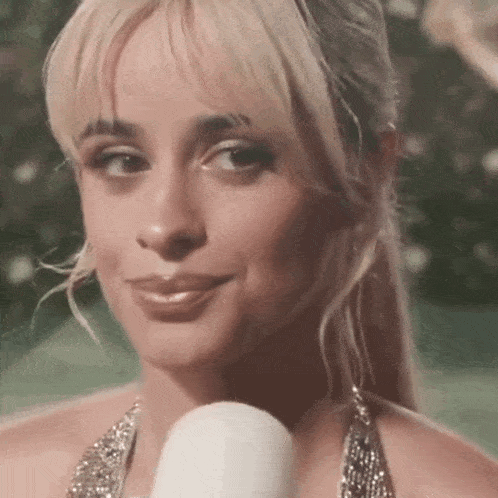 a close up of a woman holding a microphone and smiling .