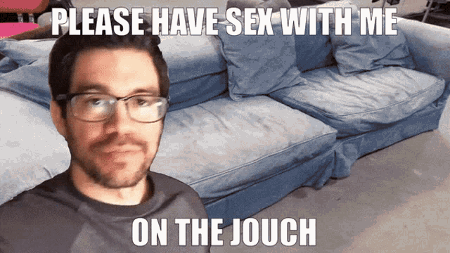 a man with glasses is standing in front of a blue couch with the words please have sex with me on the jouch