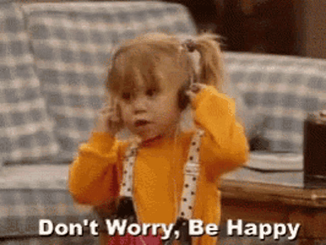 a little girl is wearing headphones and saying `` do n't worry be happy '' .