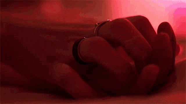 a close up of a person 's hand with a ring on their finger