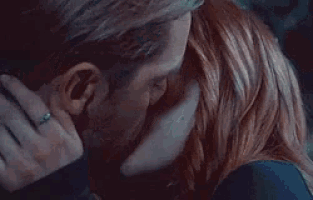 a man and a woman are kissing in a dark room at night .