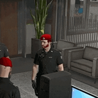 a group of police officers are standing in a room with a computer and saluting .