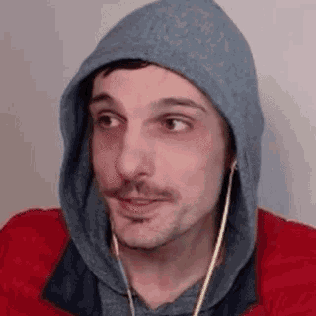a man wearing a hoodie and headphones is looking at the camera .