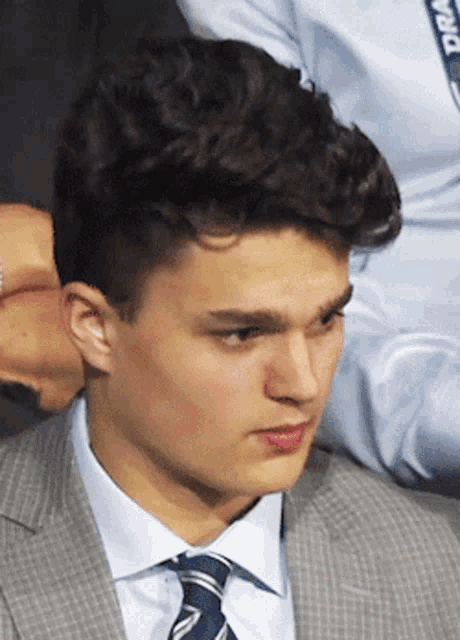 a young man in a suit and tie has a lanyard that says nba