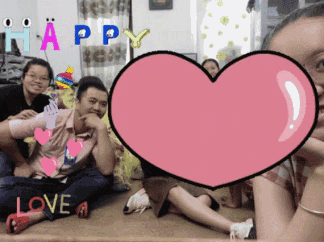 a group of people sitting on the floor with a pink heart that says love on it