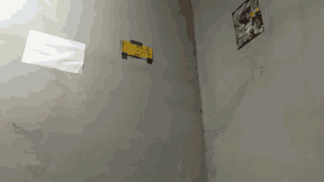 a few pieces of paper on a wall including one that says ' n ' on it