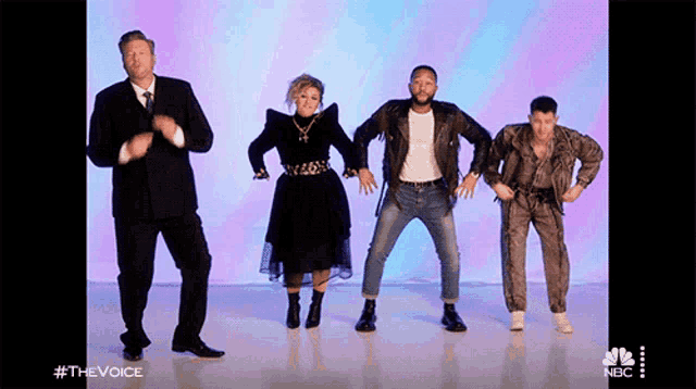 a group of people are dancing in front of a purple background with #thevoice on the bottom