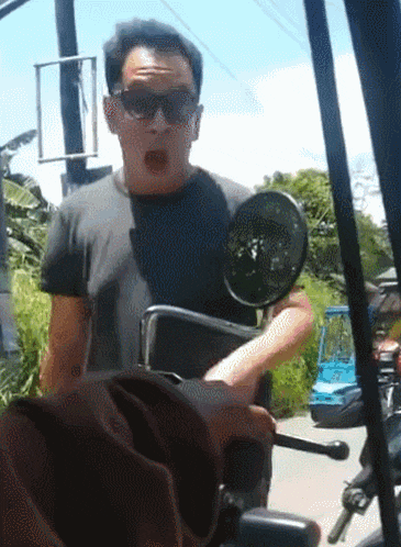 a man wearing sunglasses is holding a briefcase while riding a scooter