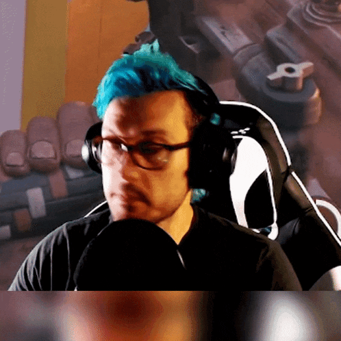 a man with blue hair is wearing headphones