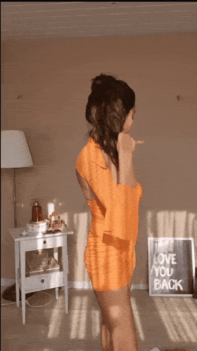 a woman stands in front of a sign that says love you back