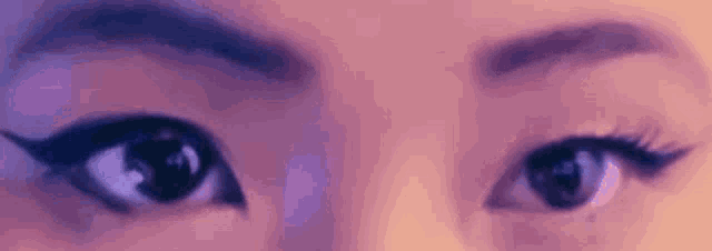 a close up of a woman 's eyes with eyeliner and lashes .