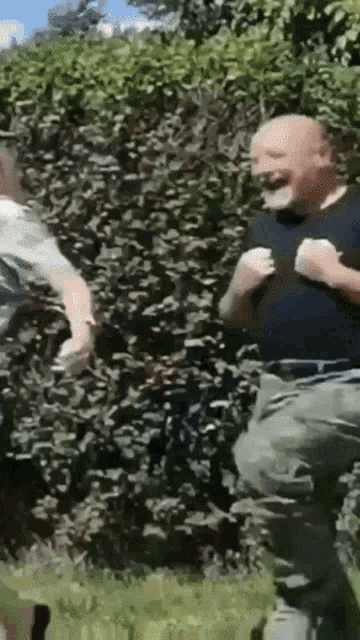 a man in a black shirt is jumping in the air while another man looks on