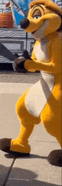 a lion king mascot is standing on a sidewalk .