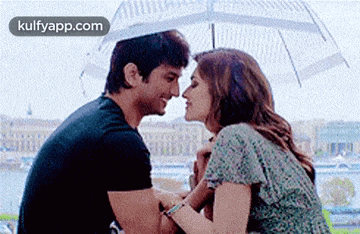 a man and a woman are kissing under a clear umbrella .