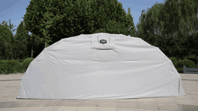 a large white tent with a black logo on the side