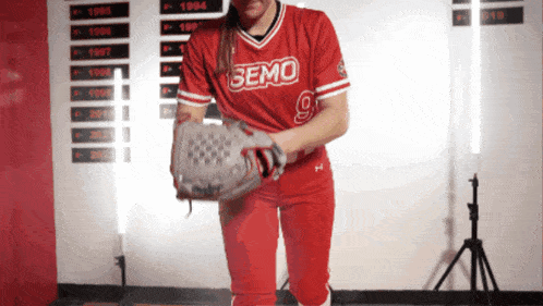 a woman in a red semo jersey holds her glove
