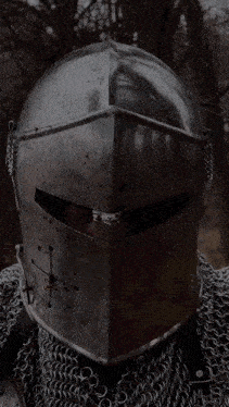 a man wearing chain mail and a helmet with a cross on it