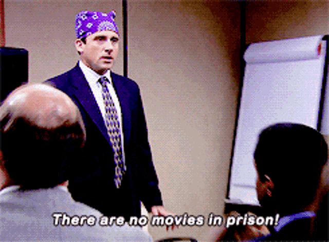 a man in a suit and tie says there are no movies in prison in front of a group of people