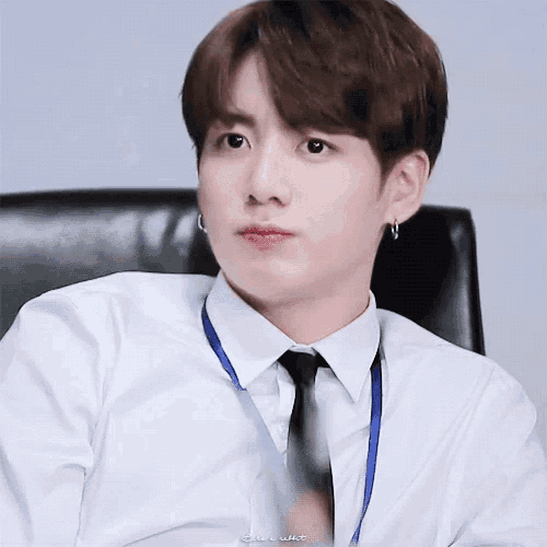 a close up of a person wearing a white shirt and tie .