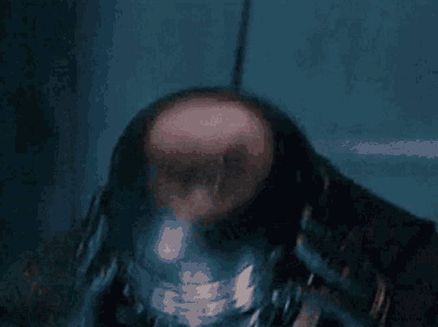 a close up of a man 's face with a serious look on his face in a dark room .