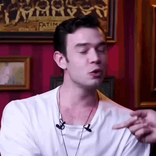a man wearing a white t-shirt with a microphone on his neck